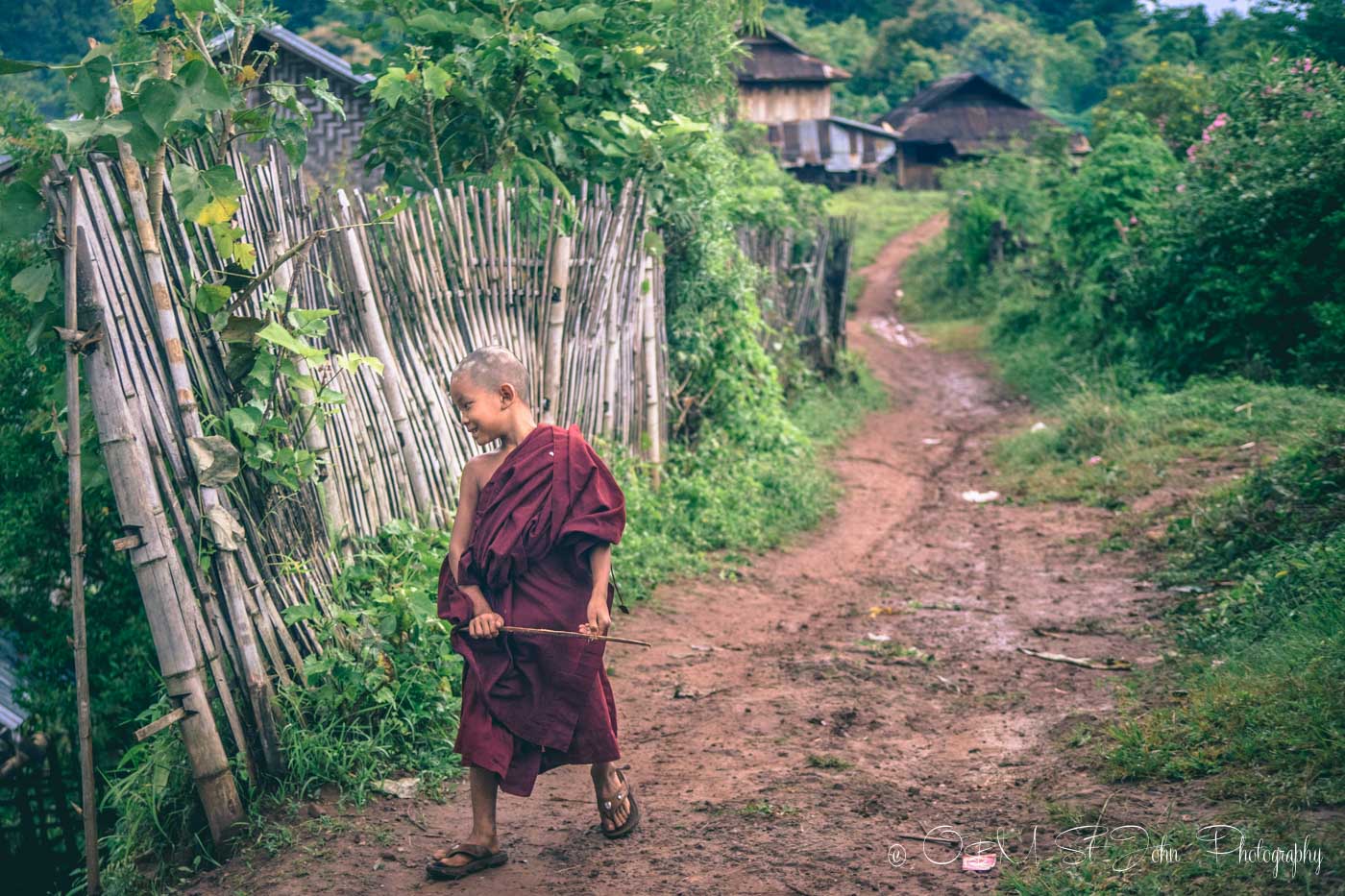Novice Burmese monk walking down the street in village in Myanmar