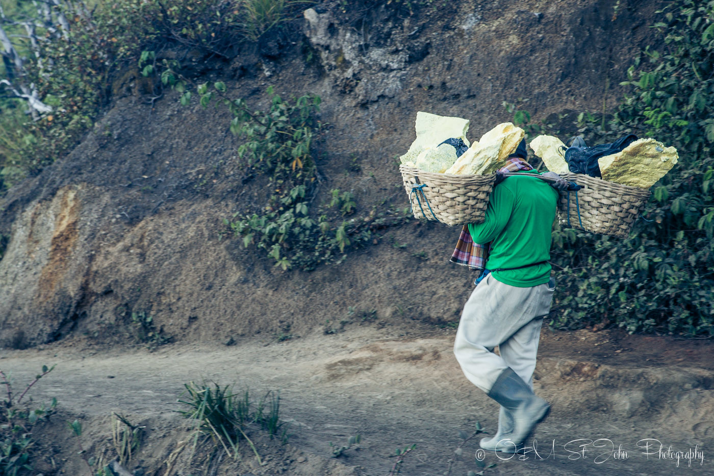 Sulfur miner making his way down with a load of sulfur. Ijen Crater. East Java. Indonesia