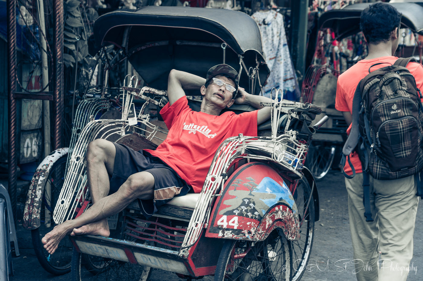 Becak driver taking a break on Jalan Malioboro before taking visitors on yogyakarta tour 