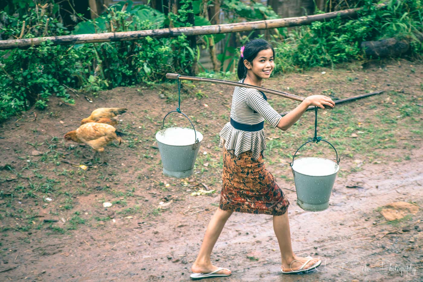 Young girl carries water to her home in Palaung Village