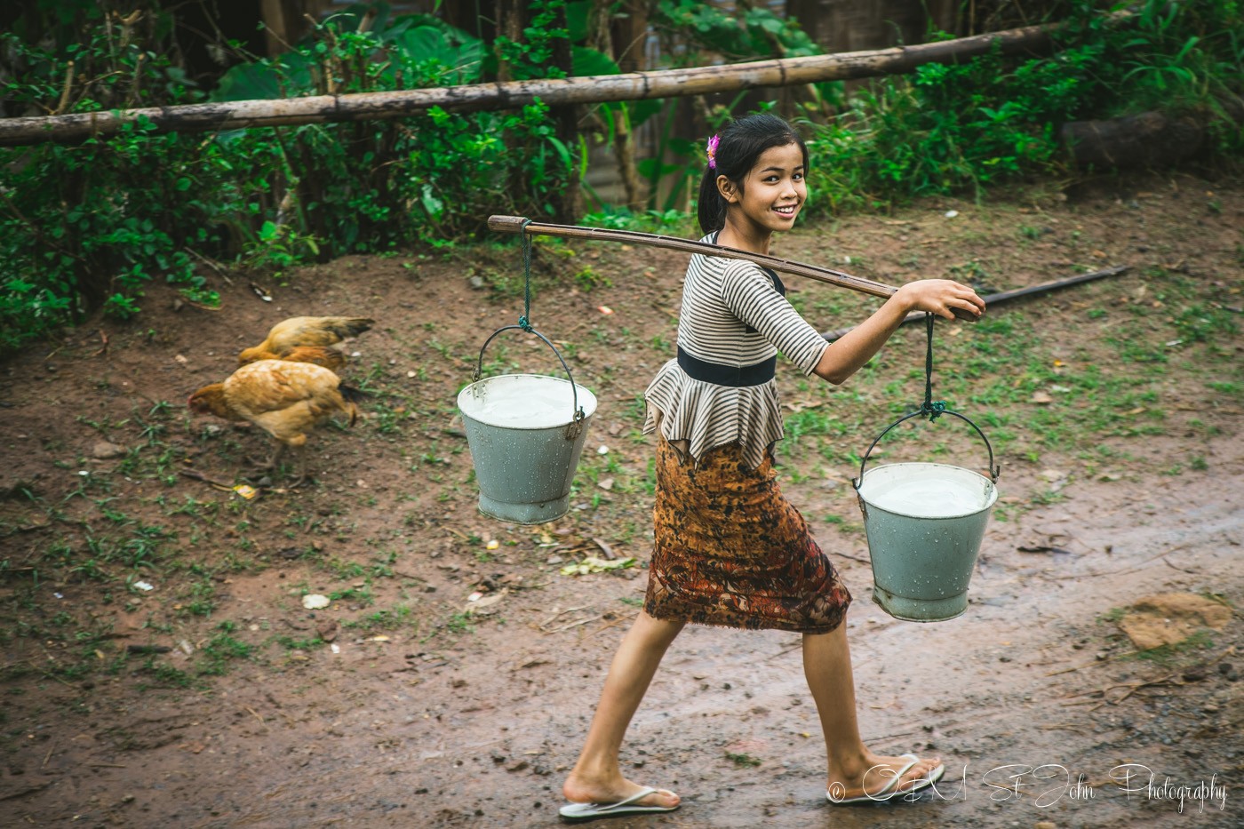 Young girl carries water to her home in Palaung Village. Hsipaw. Myanmar