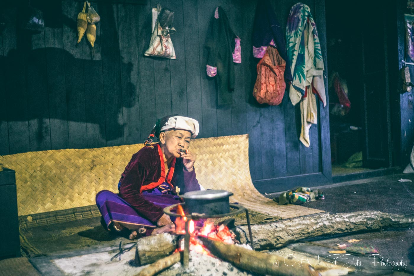 Elderly woman lights a cigar in her home in a village in Shan state, Myanmar