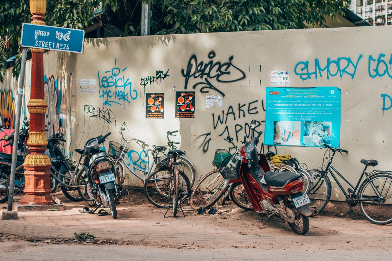 bicycles and motorcycle parked in front of wall with 1324508 1